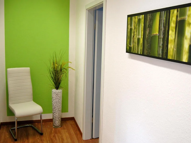 Flur mit grünem Wandfeld, Stuhl und Bambusbild